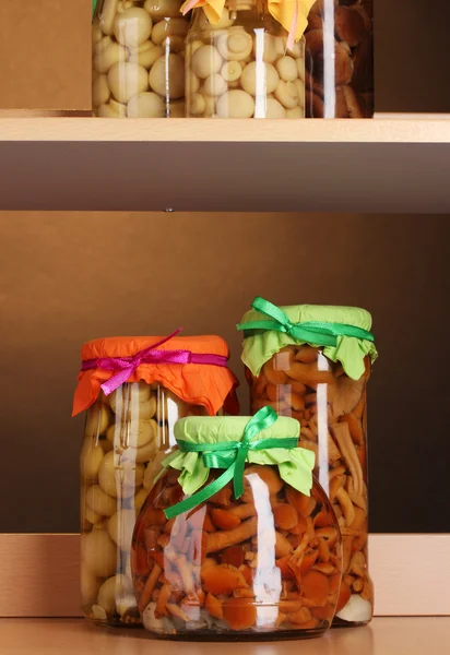 Läcker marinerad svamp i glasburkar på trä hyllor — Stockfoto