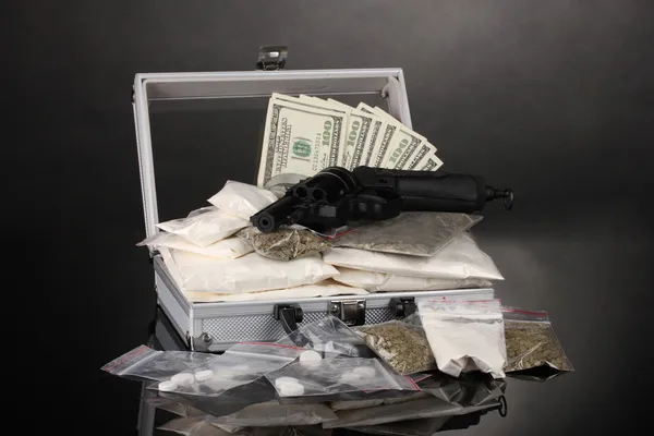 Кокаин и марихуана с пистолетом в чемодане на сером фоне — стоковое фото