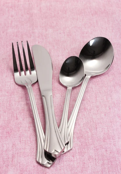 Fork, spoon and knife on a pink tablecloth — Stock Photo, Image