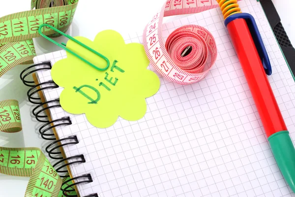Planificación de la dieta. Cintas métricas para cuadernos y bolígrafos aislados en blanco —  Fotos de Stock