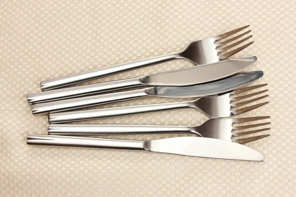 Fourchettes et couteaux sur une nappe beige — Photo