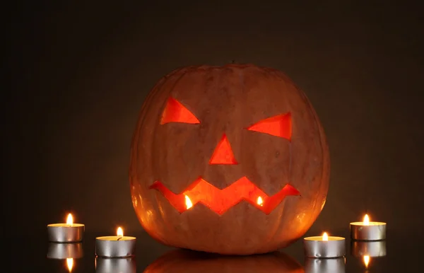 Zucca di Halloween e candele su sfondo marrone — Foto Stock