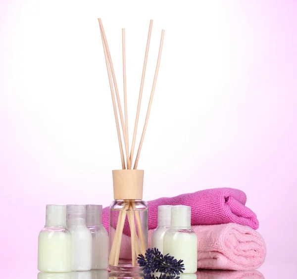 Fles luchtverfrisser, lavendel en handdoeken op roze achtergrond — Stockfoto