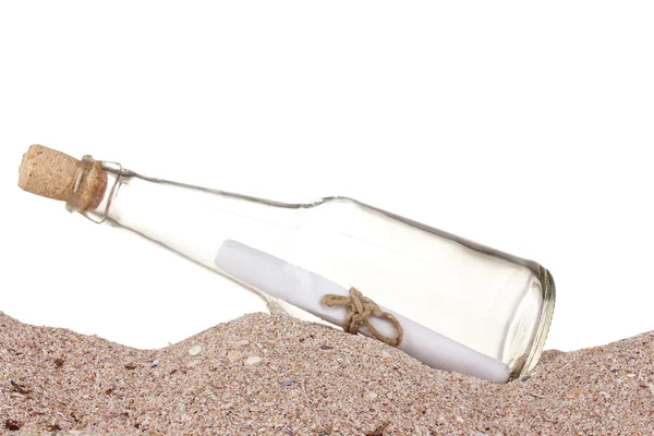 Botella de vidrio con nota interior sobre arena sobre fondo blanco — Foto de Stock