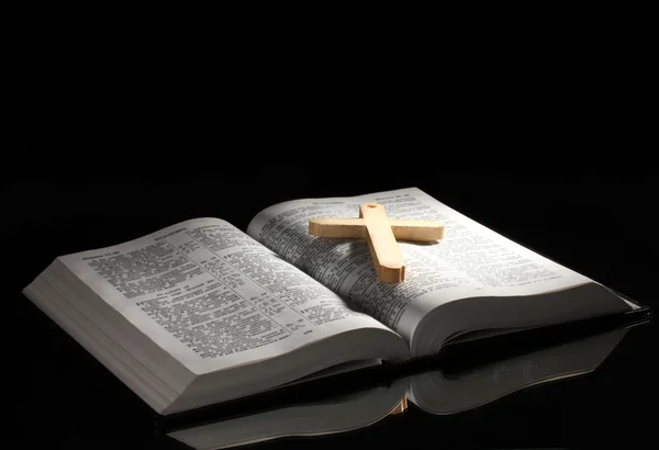 Biblia santa abierta rusa con cruz de madera sobre fondo negro — Foto de Stock