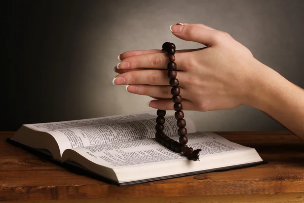 Händerna vikas i bön över öppna ryska Bibeln — Stockfoto