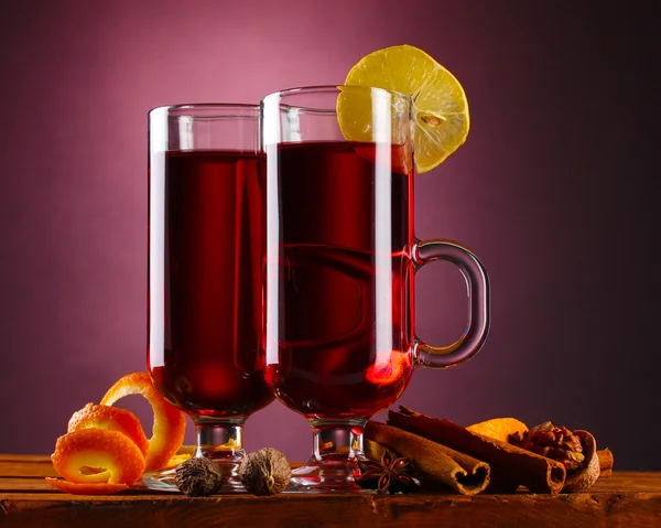 Vinho quente nos copos, tempero e limão no fundo roxo — Fotografia de Stock