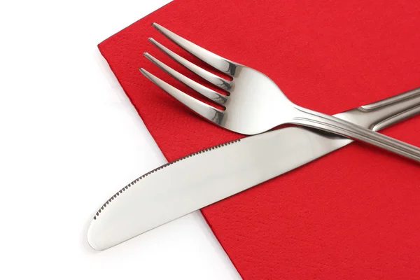 Πηρούνι και μαχαίρι σε ένα κόκκινο πανί που απομονώνονται σε λευκό — Φωτογραφία Αρχείου