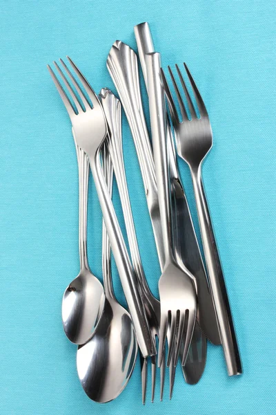 Vidličky, lžíce a nože na modrý ubrus — Stock fotografie