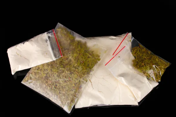Kokaina i marihuana w pakietach na czarnym tle — Zdjęcie stockowe
