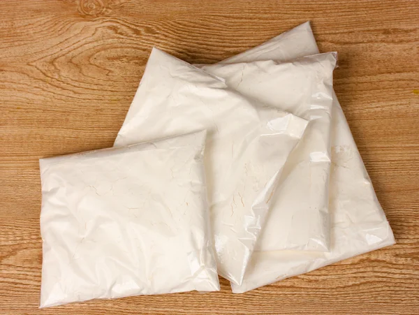 Cocaína en paquetes sobre fondo de madera — Foto de Stock