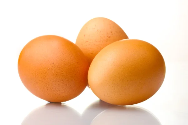Три коричневых яйца изолированы на белом — стоковое фото