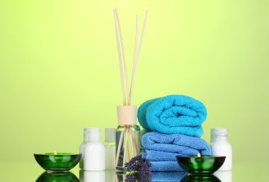 Bottle of air freshener, lavander and towels on green background clipart