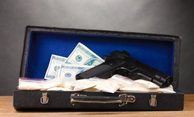 Kokain, dolar ve gri arka plan üzerinde ahşap masa durumunda tabanca