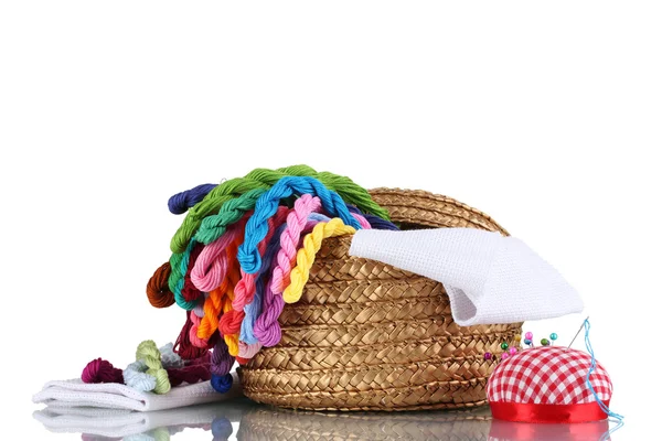 Яркие нити для рукоделия и ткани в плетеной корзине — стоковое фото