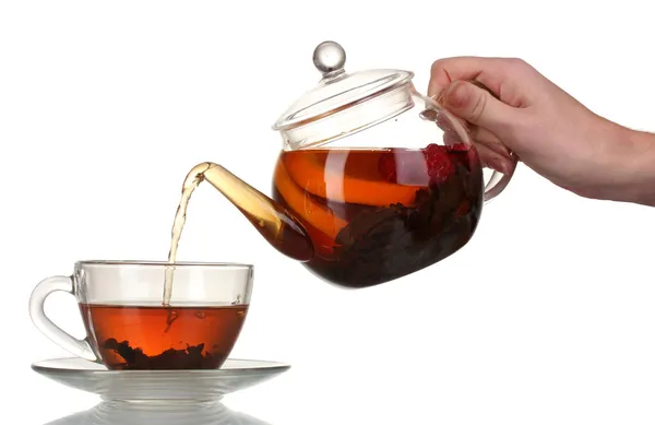 Стеклянный чайник наливая черный чай в чашку изолированы на белом — стоковое фото