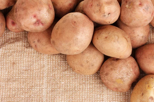 Verse aardappelen op jute close-up — Stockfoto