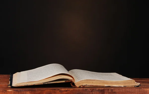 Старая книга на деревянном столе на коричневом фоне — стоковое фото