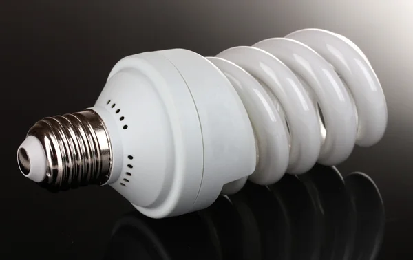 Energy saving light bulb on black background — Stock Photo, Image