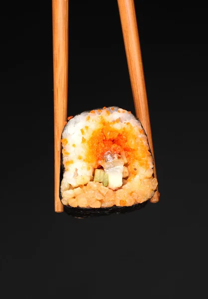 Delicioso sushi e pauzinhos no fundo preto — Fotografia de Stock