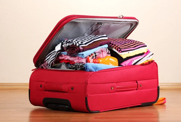 Valise ouverte rouge avec vêtements dans la chambre — Photo