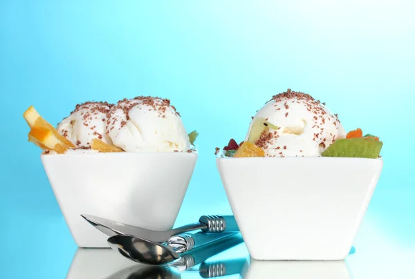 Delicioso helado de vainilla con chocolate y frutas en cuencos y cucharas o —  Fotos de Stock