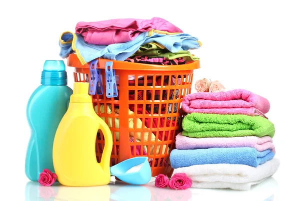 Roupas com detergente e pó de lavagem em cesta de plástico laranja isolada — Fotografia de Stock