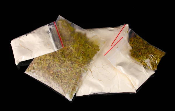 Cocaïne en marihuana in pakketten op zwarte achtergrond — Stockfoto