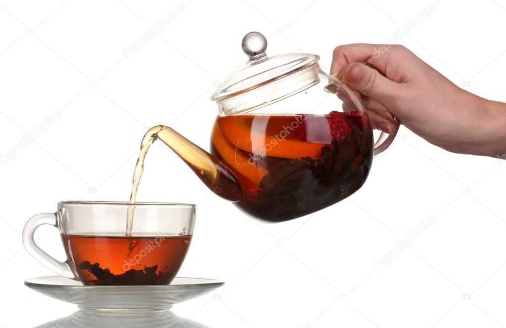 Glass teapot pouring black tea into cup isolated on white