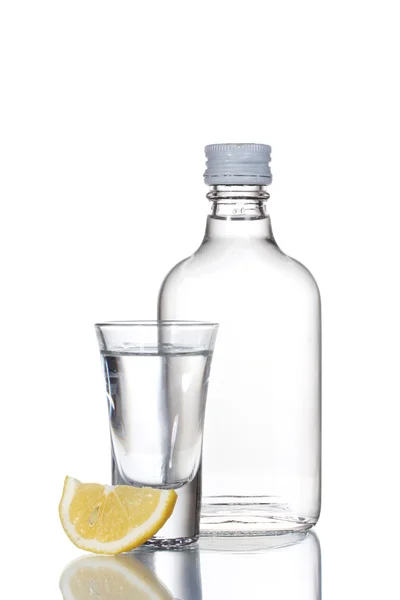 Flaska vodka och vinglas med citron isolerad på vit — Stockfoto