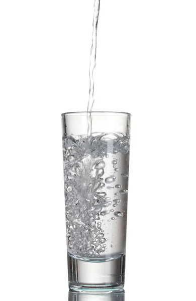 Водка наливается в стакан, изолированный на белом — стоковое фото