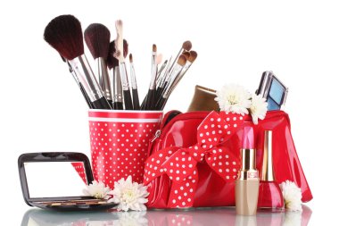 Red glass with brushes and makeup bag with cosmetics isolated on white clipart