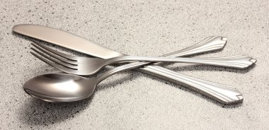 Fork, spoon and knife on marble table clipart