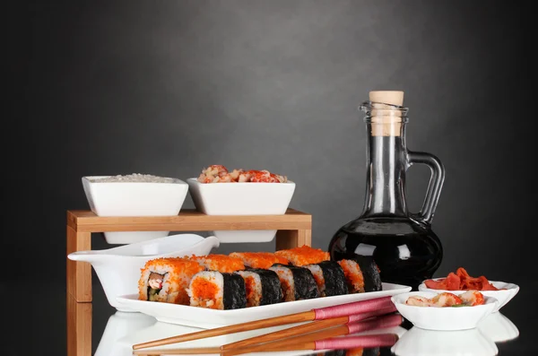 Heerlijke sushi op plaat, eetstokjes, sojasaus, vis en garnalen — Stockfoto