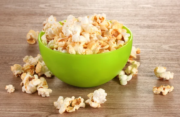 Popcorn w jasne, plastikowe miski na drewnianym stole — Zdjęcie stockowe