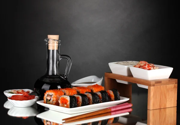 Delicioso sushi en plato, palillos, salsa de soja, pescado y camarones en gris b —  Fotos de Stock