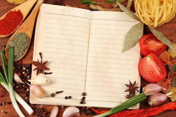 Notebook for recipes and spices on wooden table — Stock Photo, Image