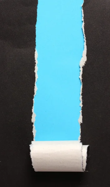 Mavi arka plana sahip siyah yırtık kağıt — Stok fotoğraf
