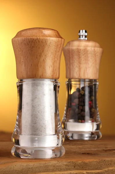 Salt and pepper mills on yellow — Stock Photo, Image