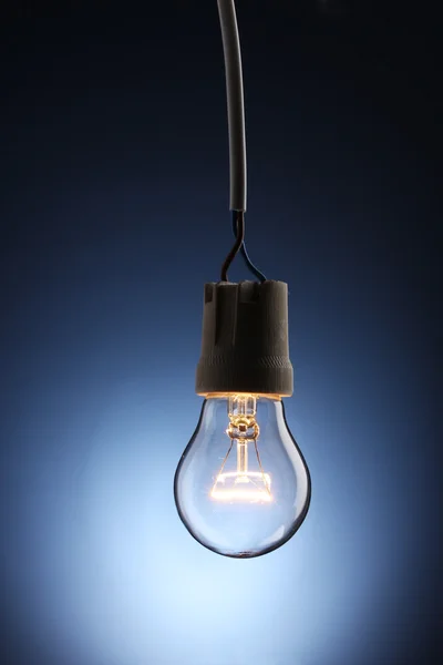 青色の背景色に点灯している電球 — ストック写真