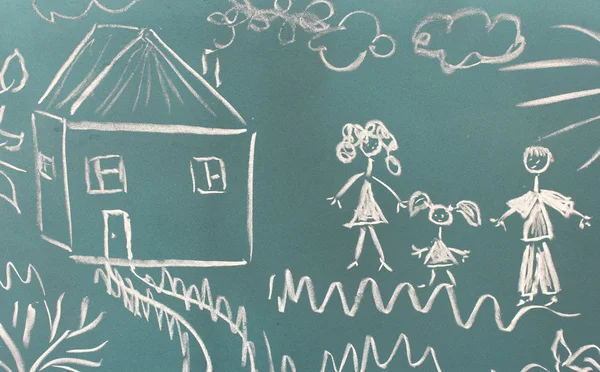 Krijtbord met tekenen met huis close-up en gelukkige familie — Stockfoto