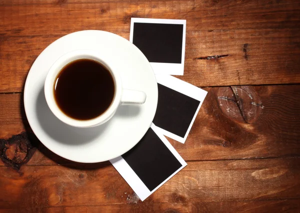 木製の背景の上にコーヒーと写真用紙 — ストック写真