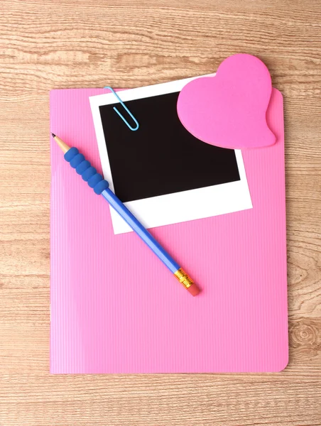 Papel fotográfico y cuaderno rosa sobre fondo de madera — Foto de Stock