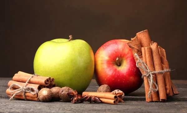 Zimtstangen, Äpfel Muskat und Anis auf Holztisch auf braunem Hintergrund — Stockfoto