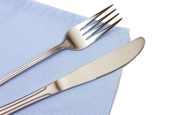 Πηρούνι και μαχαίρι σε ένα μπλε ύφασμα που απομονώνονται σε λευκό — Φωτογραφία Αρχείου
