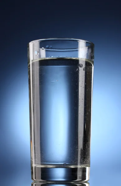Vaso de agua sobre fondo azul — Foto de Stock