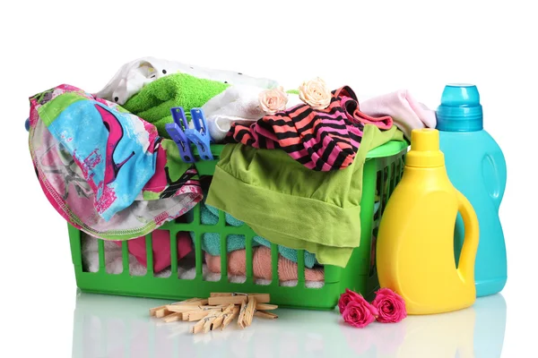 Ropa con detergente y cesta de plástico verde aislada sobre blanco — Foto de Stock