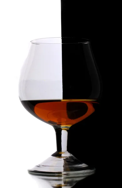 Glass of cognac on white-black background — Stock Photo, Image