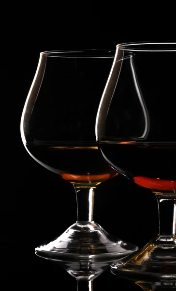 Två glas cognac på svart bakgrund — Stockfoto