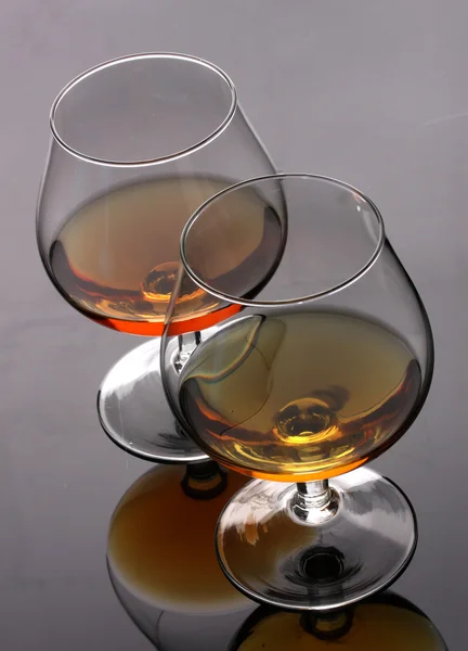 Två glas cognac på grå bakgrund — Stockfoto
